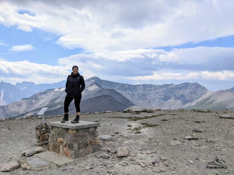 Adventuresome Jo standing on a pillar on the summit of The Whistlers with Indian Ridge in the background