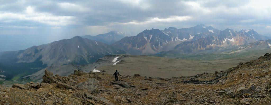 Hiker standing on Indian Ridge looking toward the far mountains in the Canadian Rockies