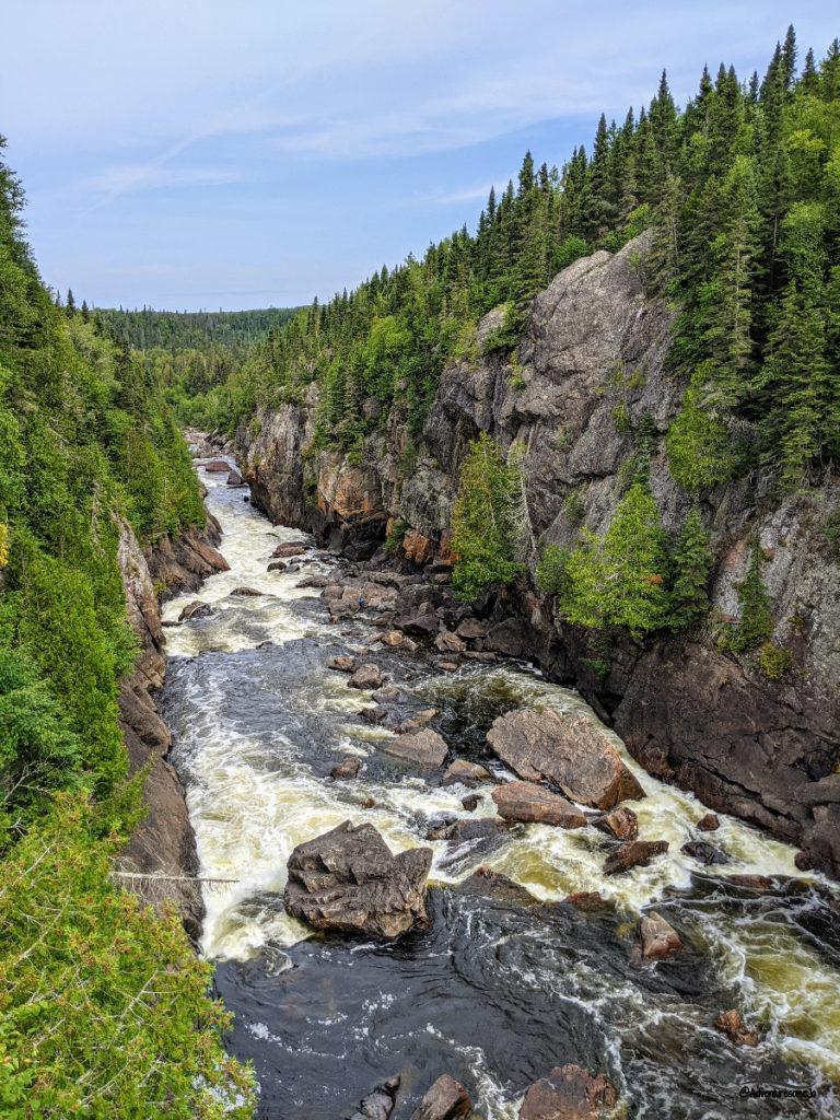 White River rapids flanked by high cliffs and conifers