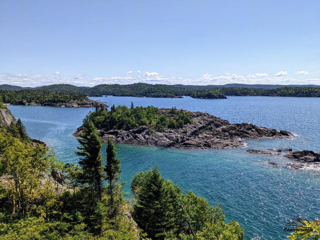 Un sentier dans le parc national Pukaskwa avec vue sur le lac Supérieur, ses eaux bleues infinies et ses rives rocheuses.