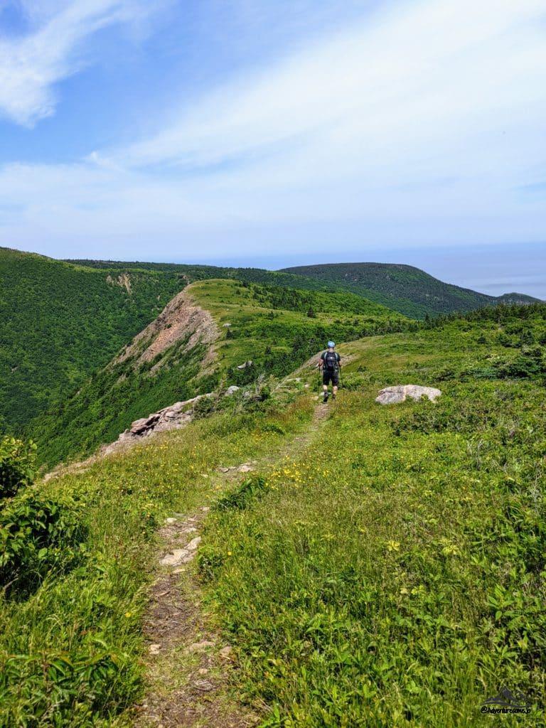 Randonneur sur le sentier herbeux de la montagne Meat Cove en Nouvelle-Écosse