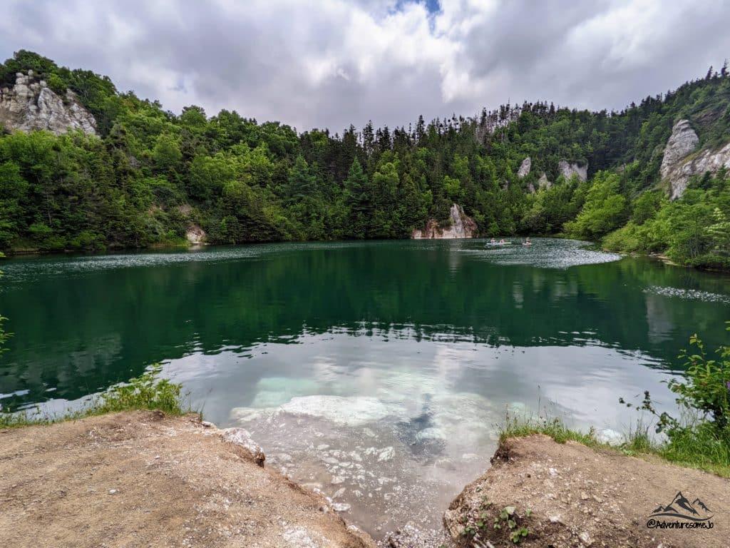 Green lake surrounded by rock wall on the Gypsum Mine Trail in Cape Breton