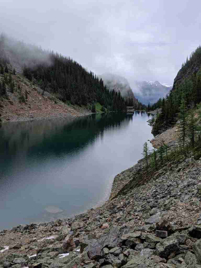 Clouds hung over Lake Agnes, with the teahouse at the far shore nestled by mountains on each side.