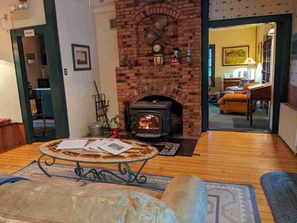 cozy room with couch and fire burning in the wood stove on a brick wall