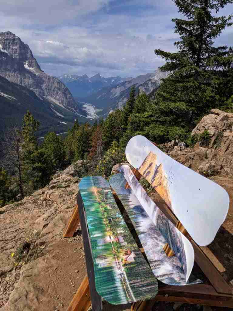 Bench made of snowboards with the Emerrald Lake painted on them at the Paget Lookout in Yoho National Park