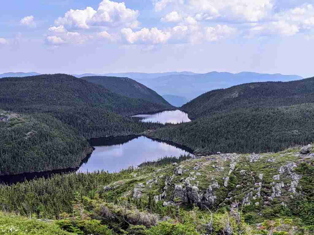 lakes nestled in green hills from the summit of Acropole des Draveurs