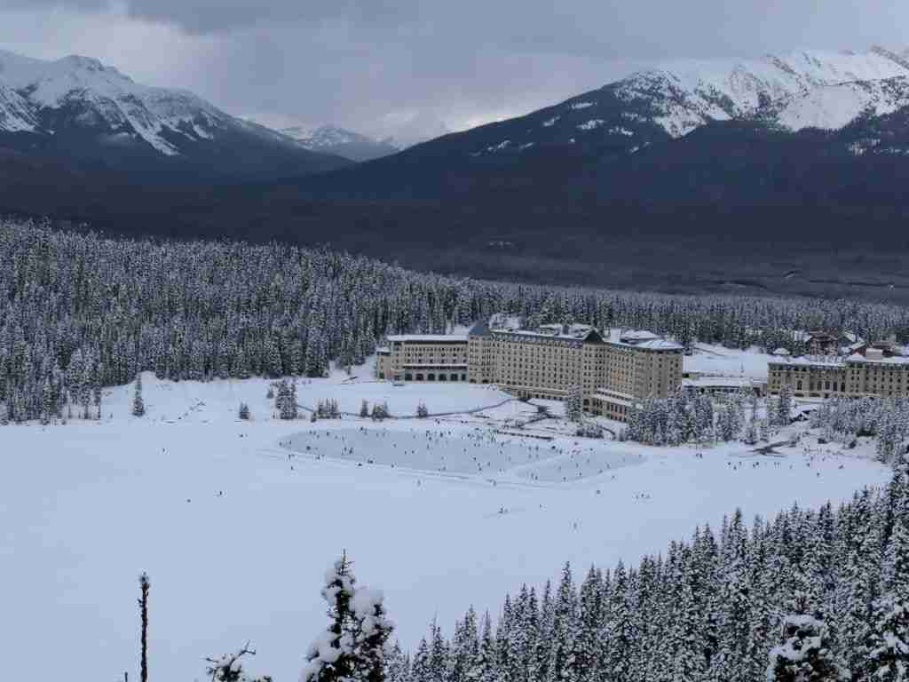 View of Lake Louise, the skaters and Fairmont Chateau Lake Louise from the Fairview Lookout in winter