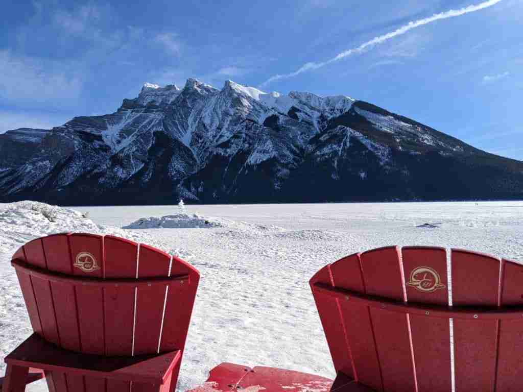 red chairs on frozen Lake Minnewanka in winter in Banff