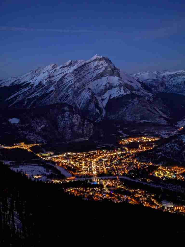 Night view of Banff illuminated by street lights and Cascade Mountain in winter