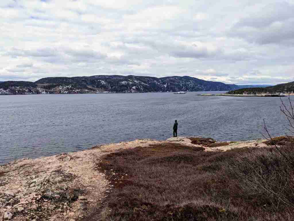 standing on the coast of the St Lawrence River looking towards Tadoussac and the ferry boat