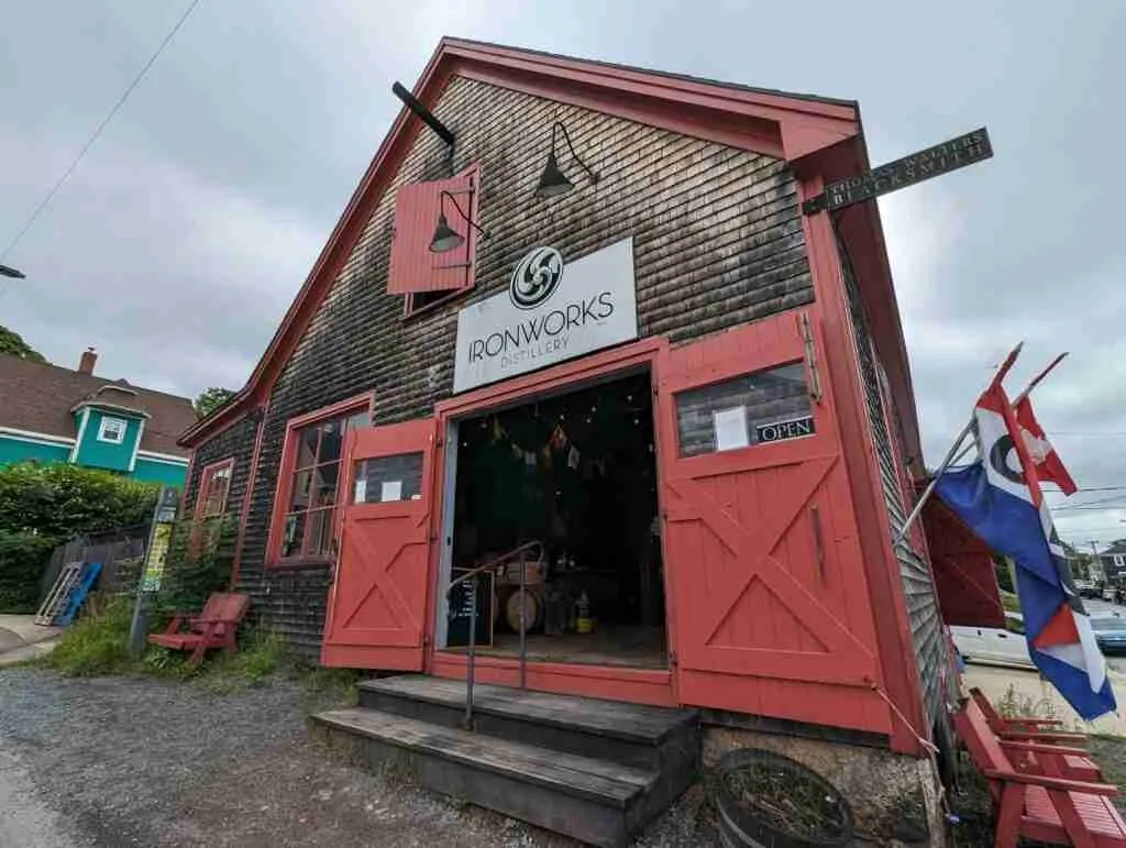 Historic wooded building with red trims for the Ironworks Distillery in Lunenburg Nova Scotia