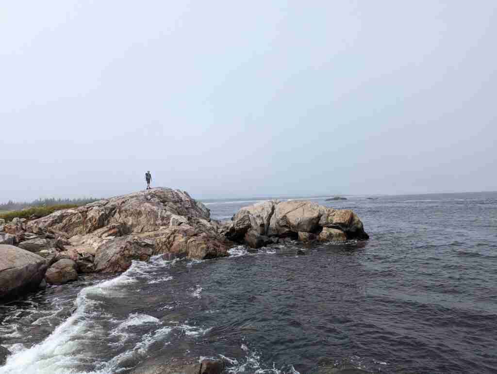 Hiker on the rocky coastal trail in Kejimkujik National Park Seaside