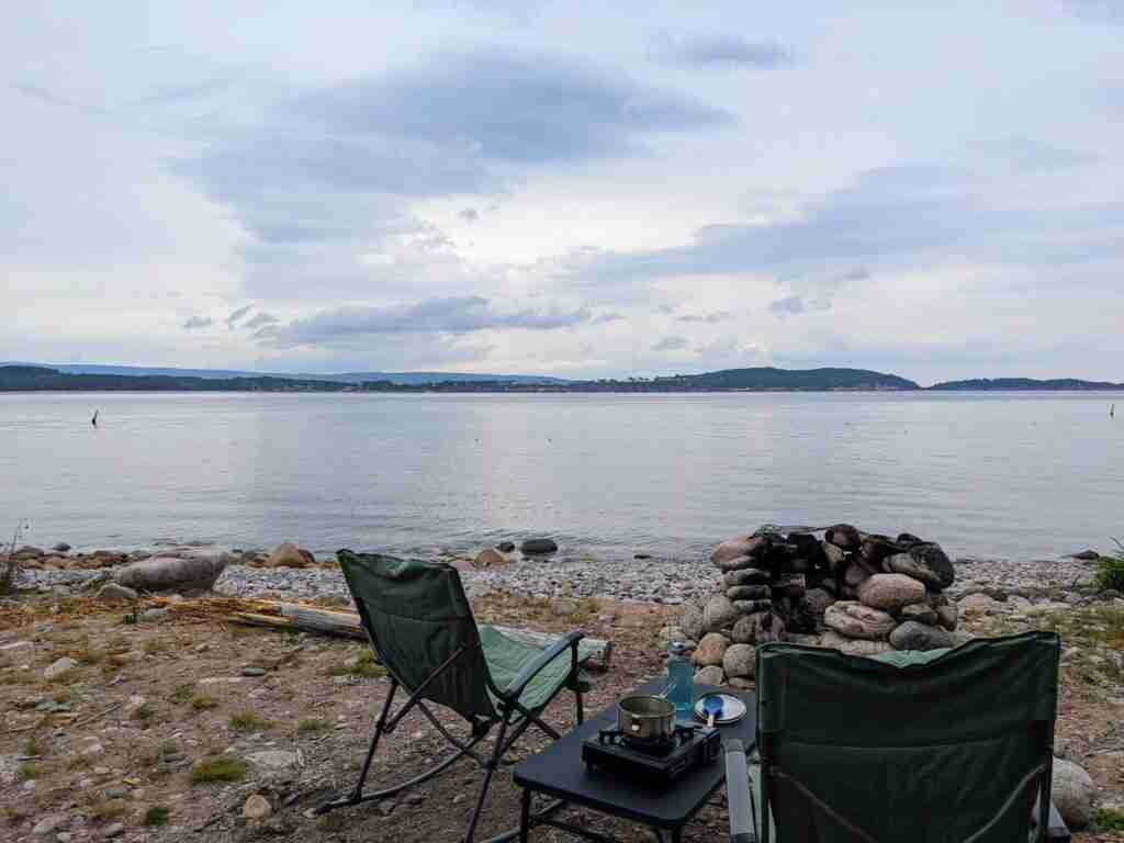 deux chaises de camp près d'un foyer pour feu de camp face à l'eau du port d'Ingonish en Nouvelle-Écosse