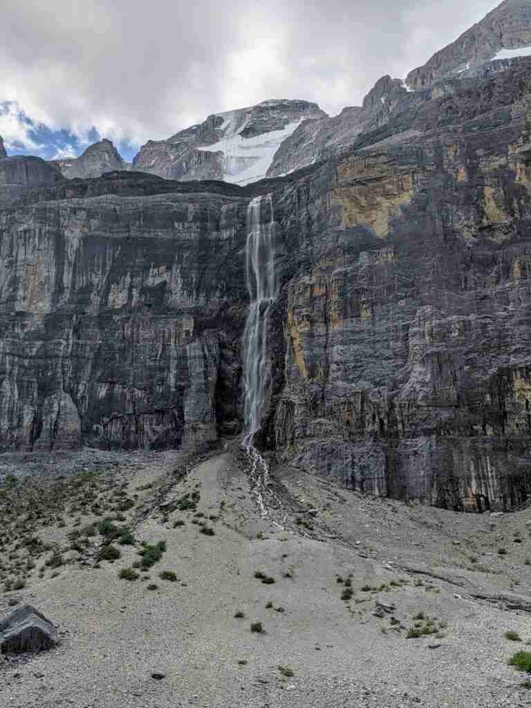 thin but high waterfall cascading down a rock wall