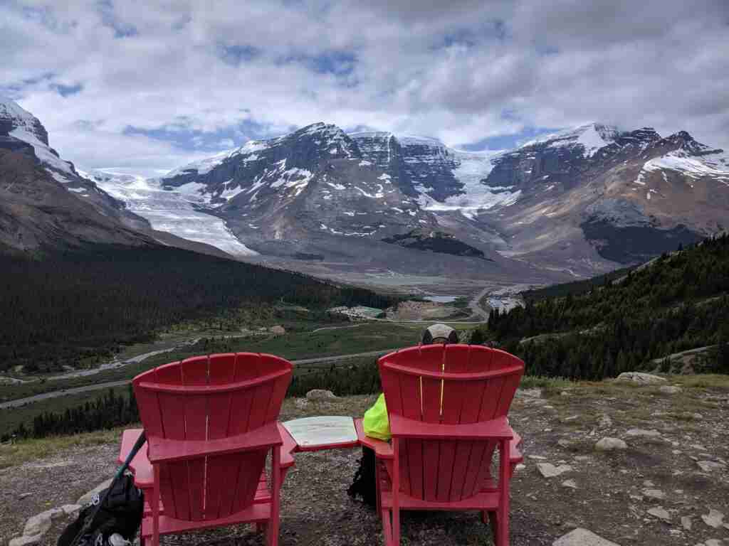 Les célèbres chaises rouges de Parcs Canada surplombant la vallée et les glaciers Athasca et Dome lors de la randonnée du col Wilcox