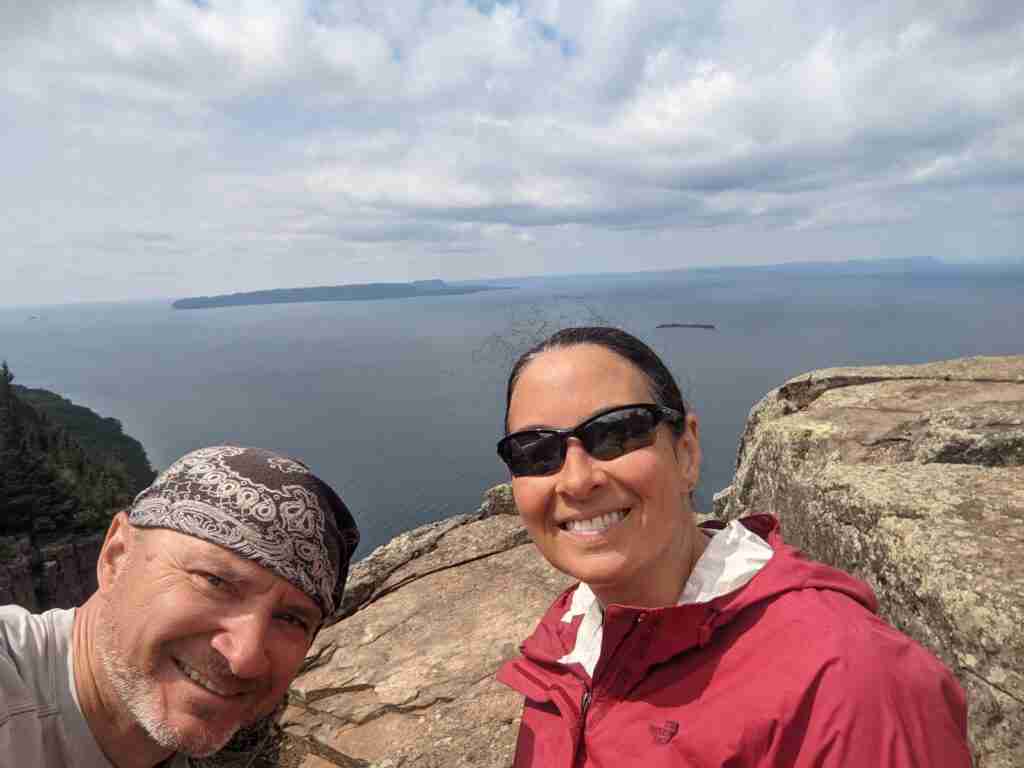 hikers taking a selfie with Lake Superior in background on a sunny day
