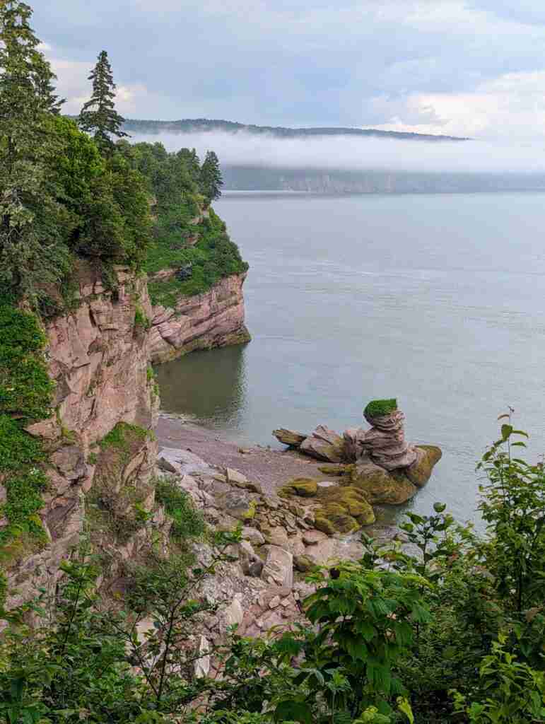 lookout from a trail on the fundy parkway with pillars of rocks and sheer cliffs and the Bay of Fundy