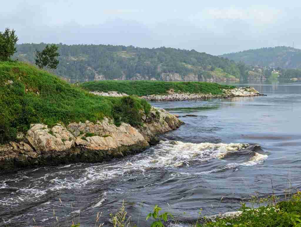 Reversing Falls Rapids surounded by rocky and green hills in Saint John