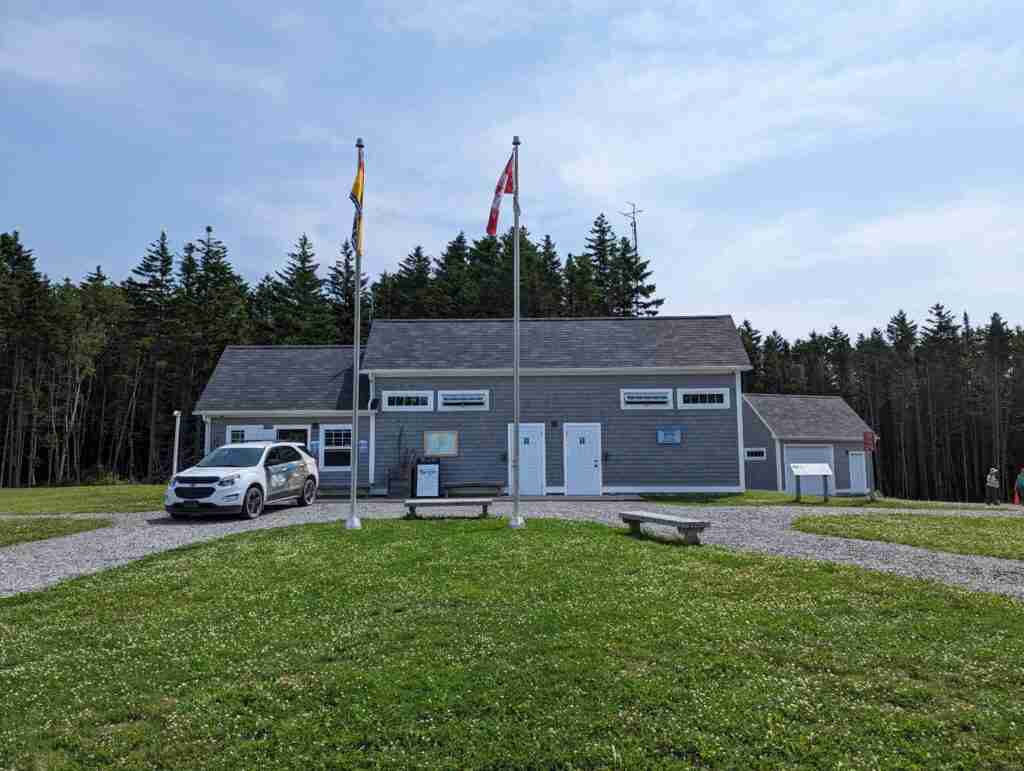 the Walton Glen reception centre and the Canadian and New Brunswick flags on posts in front the the Fundy Trail Parkway centre