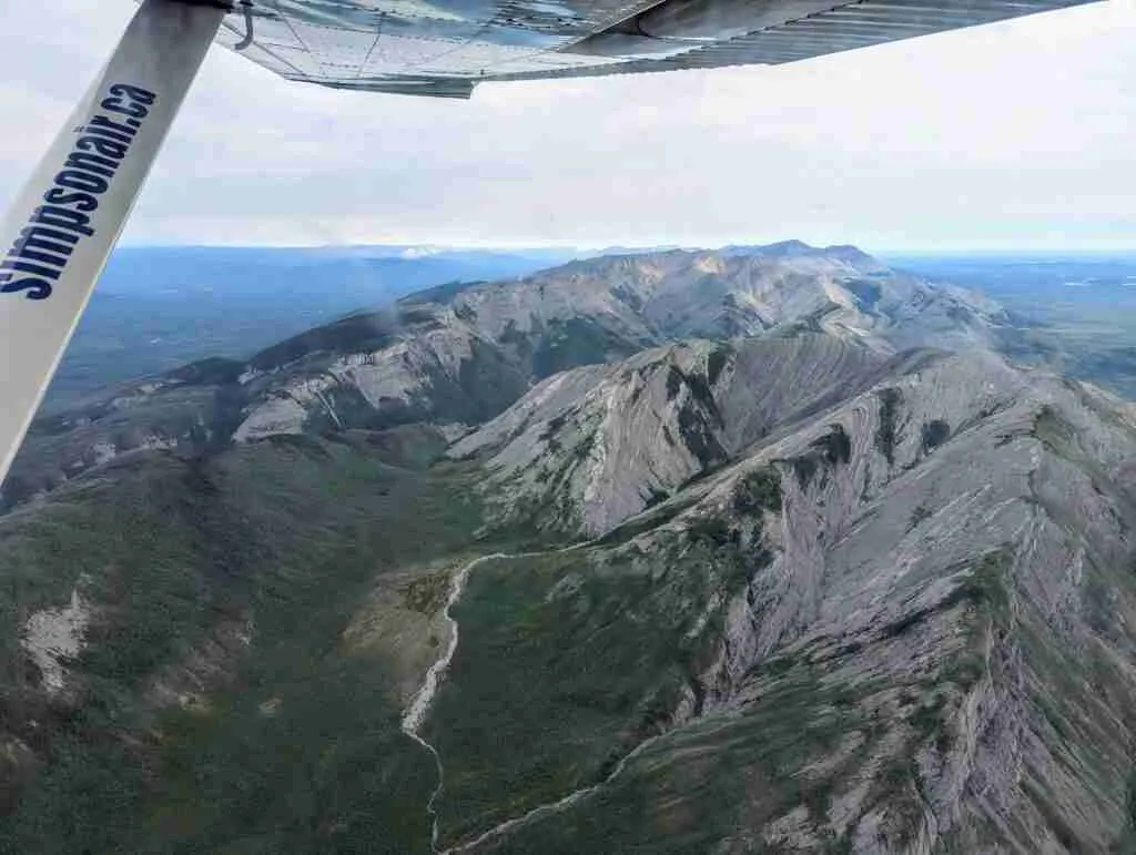 view of mountains and green valley in Nahanni National Park from the plane