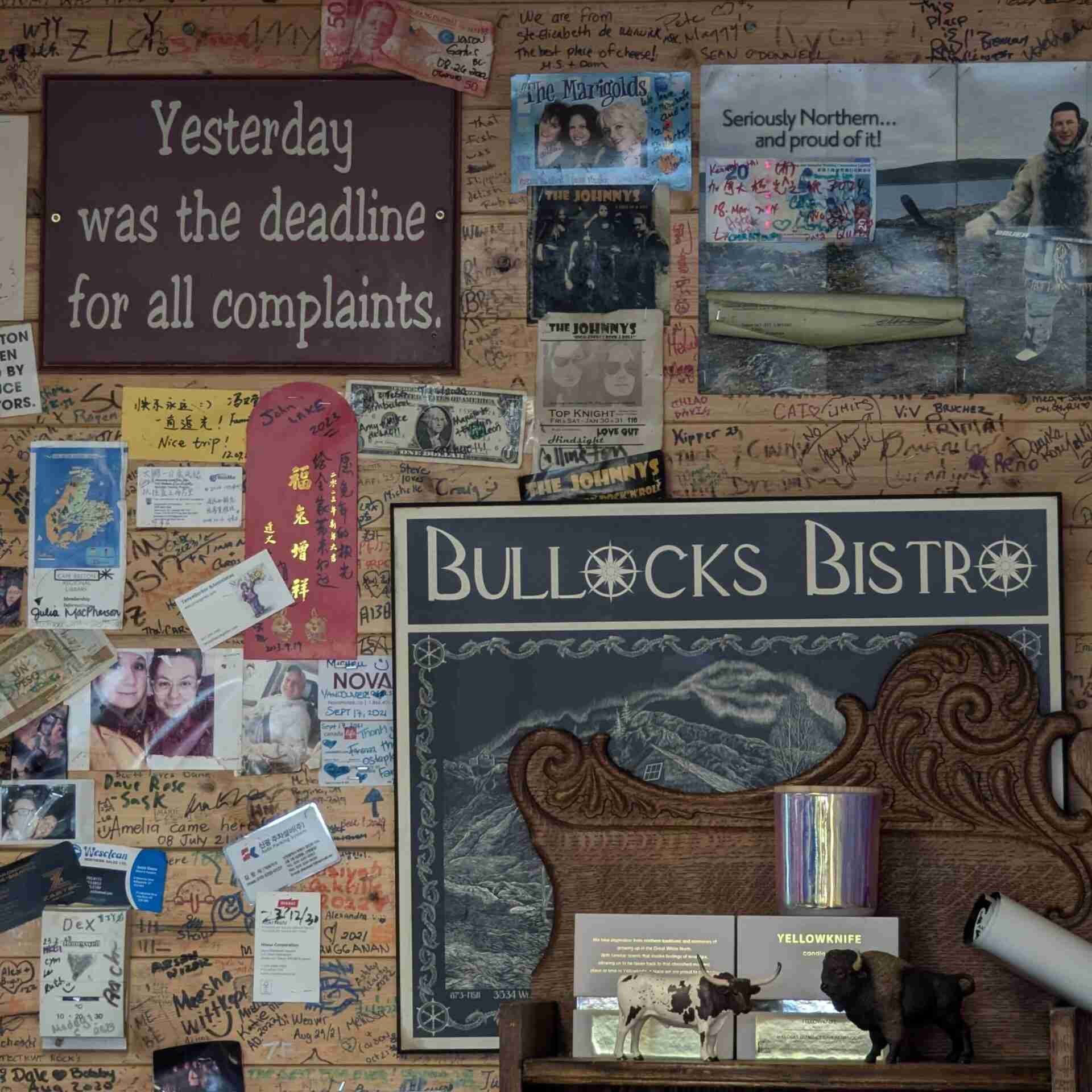 un mur du restaurant Bullock's Bistro à Yellowknike rempli de signatures et de photographies de clients