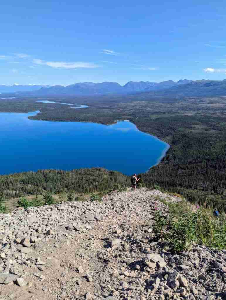 randonneur descendant le sentier rocheux et escarpé de King's Throne avec le lac Kathleen en contrebas