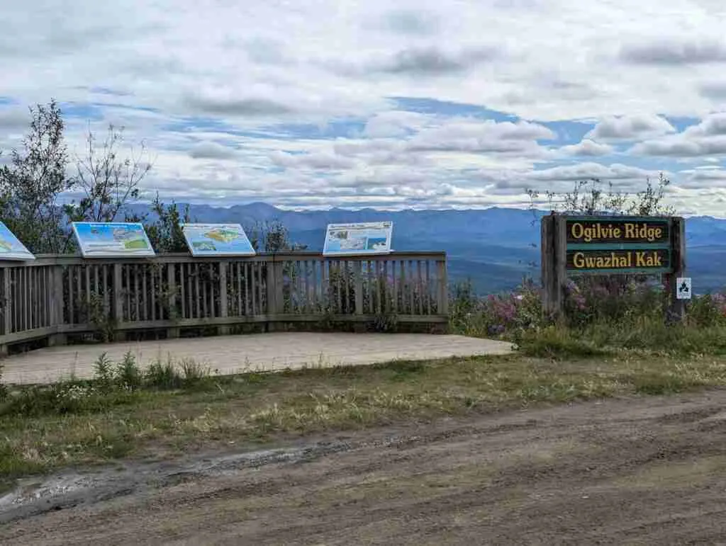 Lookout area of the Ogilvie Ridge with interpretive signs and the mountains in the distance