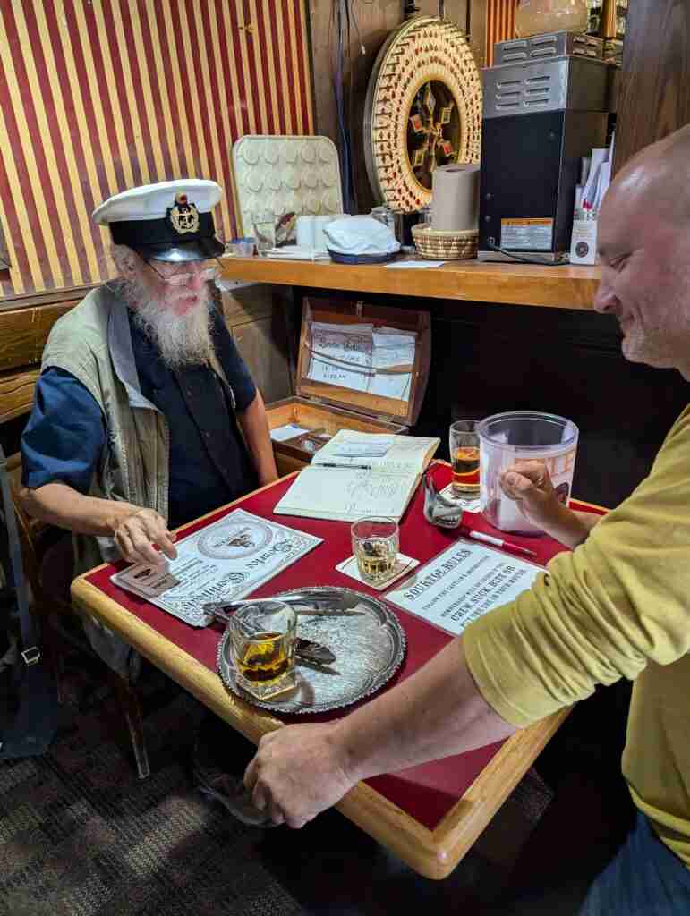 capitaine lisant les règles du cocktail sourtoe à un touriste