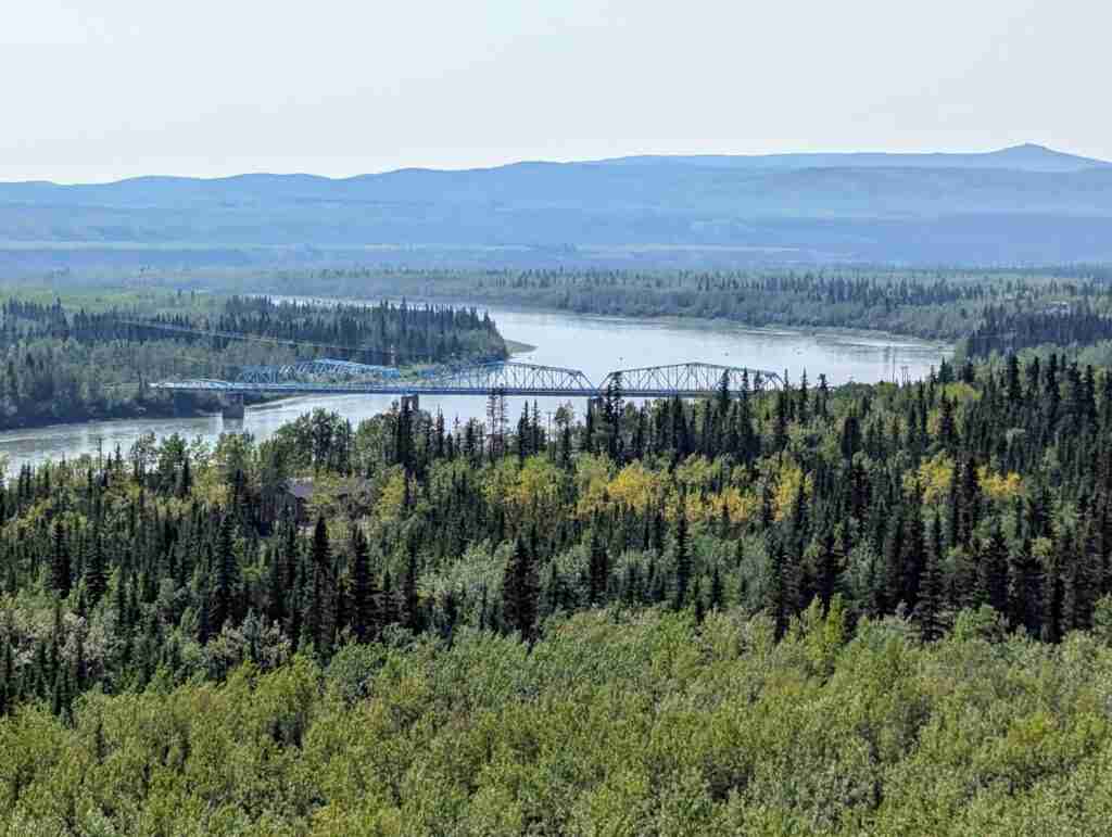 vue sur une vaste forêt avec un pont au dessus du fleuve Yukon