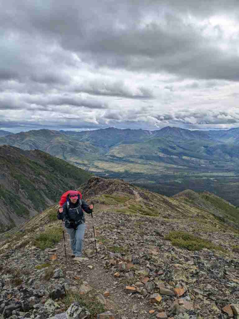 backpacker on the Grizzly Lake Trail with the view of the mountains
