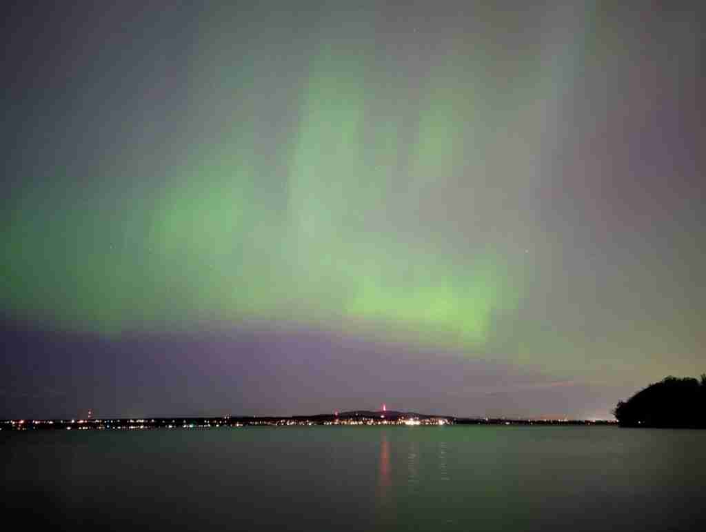 aurores boréales vertes au dessus d'un lac au Canada