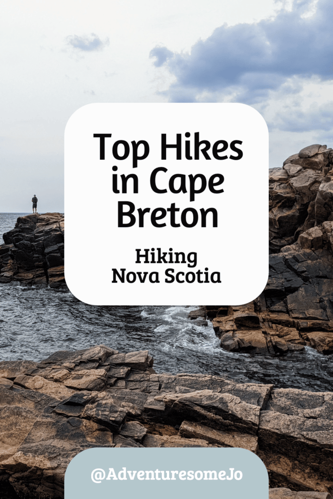 hiker standing on the rocks by the shore of Cape Breton in Nova Scotia