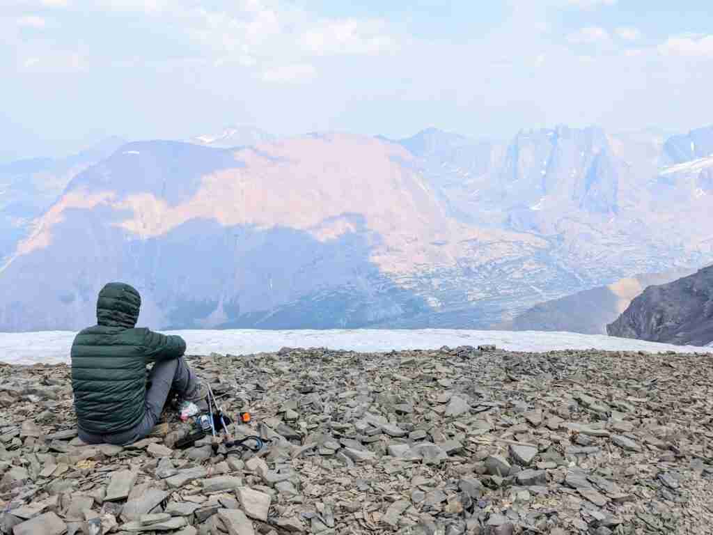 Hiker wearing a down jacket on the summit of Tangle Ridge